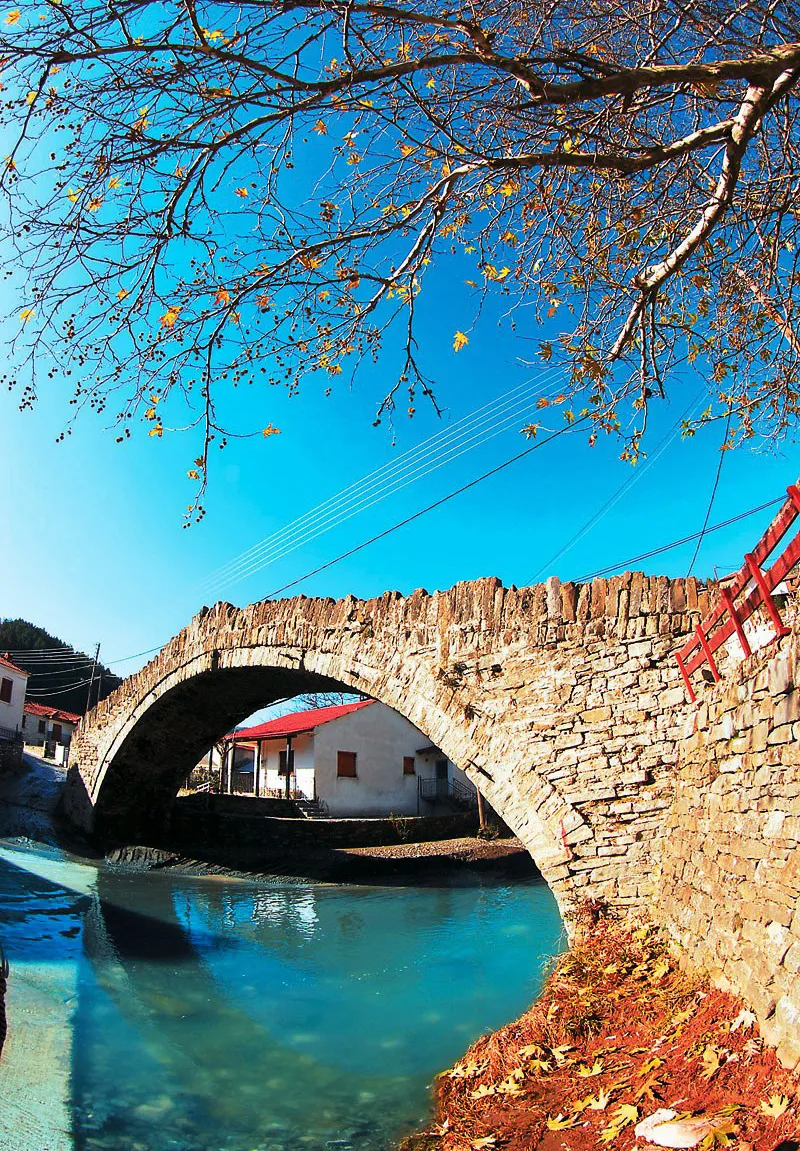 Το πέτρινο Γεφύρι του Δοτσικού ανάμεσα στα σπίτια του χωριού