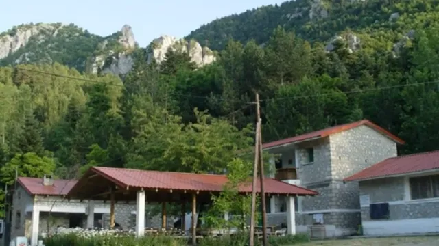 Πέτρινα κτίρια των κατασκηνώσεων με τον Όρλιακα πίσω